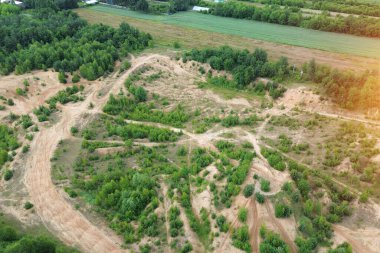Çamurlu bisiklet yollarıyla ormanın havadan çekilmiş görüntüsü.