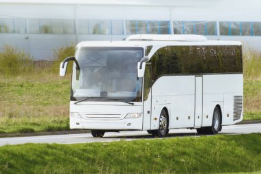 Beyaz yolcu otobüsü banliyö yolunda ilerliyor