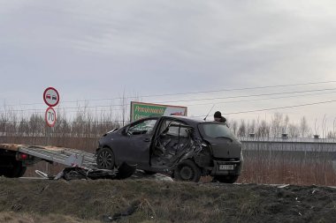 02.02.2024 Polonya, Avrupa. Çarpışmadan sonra otobanda hasarlı bir siyah hatchback arabasını yükleyen bir çekici. Toyota 'ya başka bir araç çarptı ve ağır hasar aldı. Toplam kayıp araba