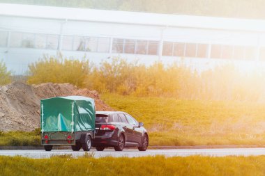 Araba kapalı bir karavanı dışarı çekiyor.