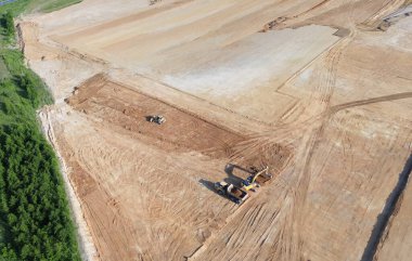 Buldozerler ve kamyonlar yer seviyesini yükseltiyor.