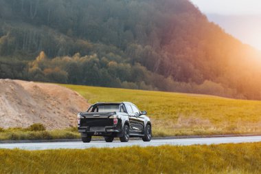 Şafakta siyah bir kamyoneti olan kırsal yol.