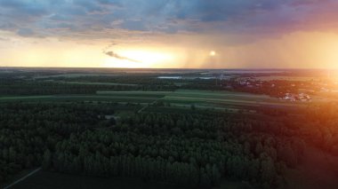 Fırtına bulutları ve gün batımı ışığıyla kırsal manzara