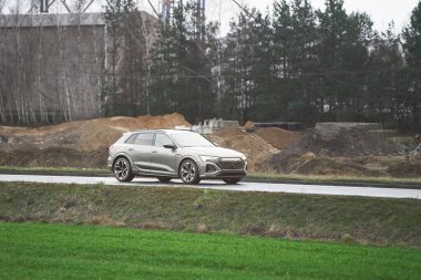 Ormanın yakınındaki yolda giden kompakt arazi aracı.