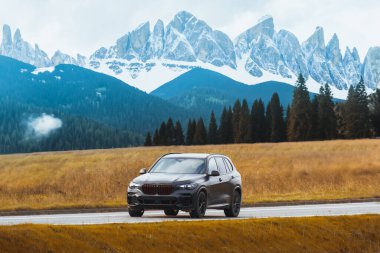 Luxury expensive family black suv driving on countryside road clipart