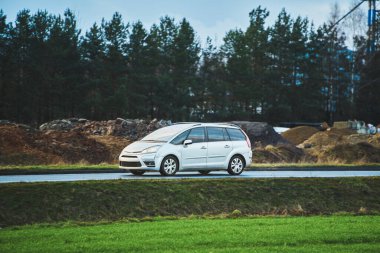 Doğada ıslak kırsal yolda giden çapraz bir araç.