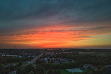 Göz kamaştırıcı bir gün batımı, yağmur ve kırsal alanda renkli gökyüzü.
