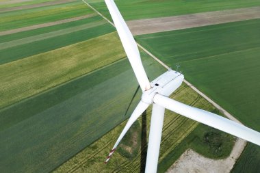 Mavi gökyüzünün altındaki kırsal bölgede rüzgar türbini