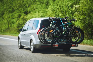 Car with bikes securely attached to a rear rack, ready for an outdoor adventure for the whole family and friends.