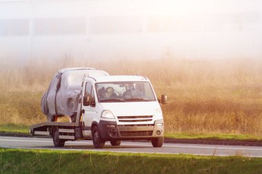 Çekici, üstü kapalı klasik araba taşıyor.
