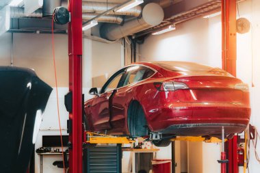 Modern EV profesyoneller tarafından bir garajda tamir ediliyor.