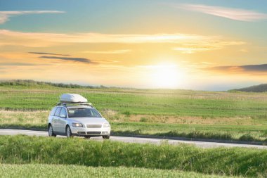 Çatı katlı araba manzaranın içinden geçiyor.