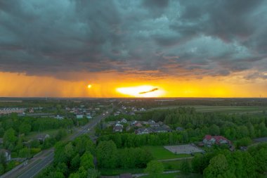 Kırsal kesimde gün batımı ve karanlık fırtına bulutları