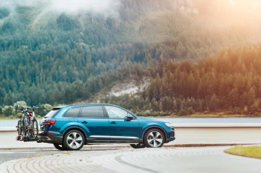 Ormandaki göl kenarında bisiklet parkı olan bir araba.