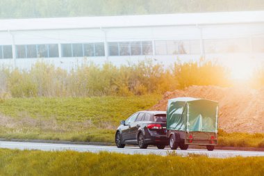 Araba ve kapalı karavan yolda gidiyor.