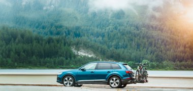 Alplerin yakınında bisiklet süren SUV 'nin yan görüntüsü