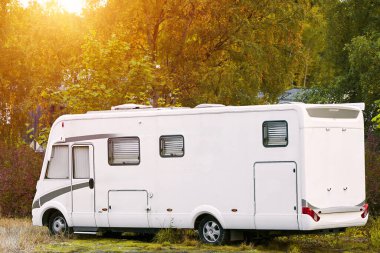 Huzurlu bir ormanlık alanda bir karavan.