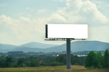 Yol kenarındaki reklam panosunda yol tabelasının yanında boşluk var.