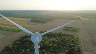 Rüzgâr türbini kırsal bir alanda duruyor ve yakındaki bir köy için temiz enerji üretiyor.