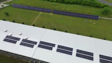 Güneş panelleri temiz enerji üreten bir endüstriyel tesisin çatısını kaplıyor.