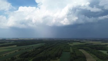 Fırtınalı bulutların altında uzanan yeşil alanlar
