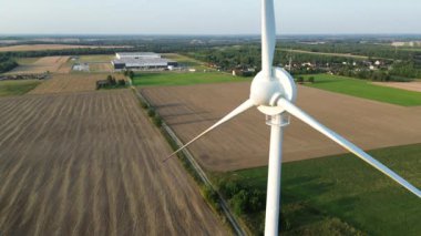 Yeşil bir tarlada rüzgar türbinleriyle günbatımı manzarası