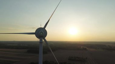 Kırsalda günbatımına karşı rüzgar türbini