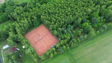 Tenis kortlarını çevreleyen yeşil orman