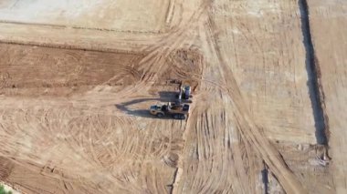 Buldozerler ve kamyonlar yer seviyesini yükseltiyor.