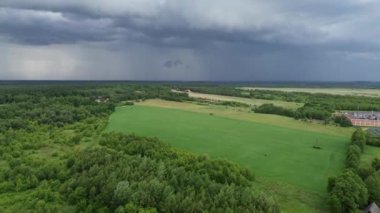 Yeşil tarlalar ve orman üzerinde fırtına bulutları