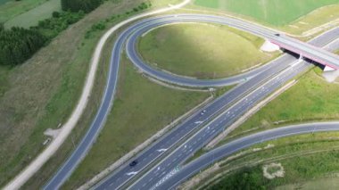 Arabalar ve yeşil manzaralı kırsal otoyol kavşağının yüksek görüntüsü
