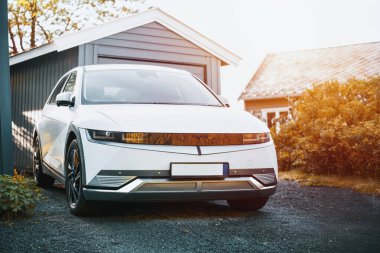 Parlak beyaz elektrikli SUV dışarıda park halinde.