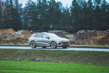 Kırsal kesimde asfalt yol boyunca giden modern SUV