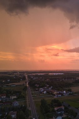 Küçük bir kasabada yaz akşamları ağır bulutlarla dolu turuncu gün batımı