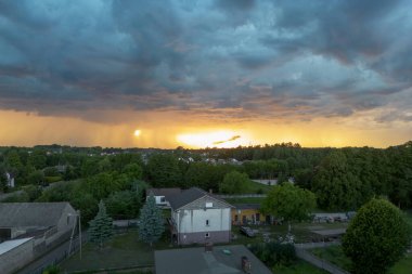Şehir ve kırsal alanda gün batımında dramatik bir gökyüzü.