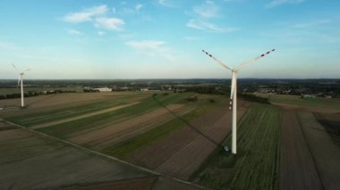 Gün batımında açık kırlarda yel değirmenleri