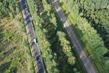 Demiryolu ve otoyolun havadan görünüşü gür orman manzarasını kesiyor.