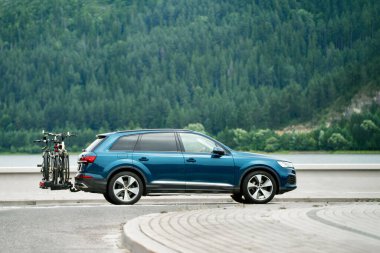 Bisikletli SUV gölün yanından geçiyor.