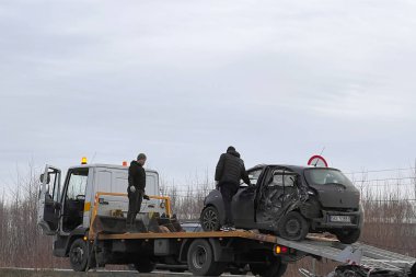 02.02.2024 Polonya, Avrupa. Çarpışmadan sonra otobanda hasarlı bir siyah hatchback arabasını yükleyen bir çekici. Toyota 'ya başka bir araç çarptı ve ağır hasar aldı. Toplam kayıp araba