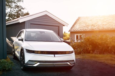 Modern beyaz elektrikli jipin ön görüntüsü park edilmiş.