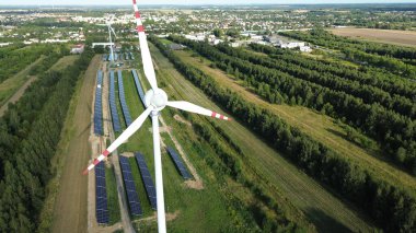 Rüzgar türbini ve güneş panelleri mavi gökyüzünün altında