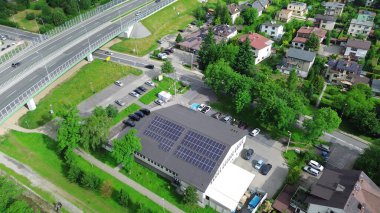 Otoparkı ve ağaçları olan güneş enerjili bir bakkal.