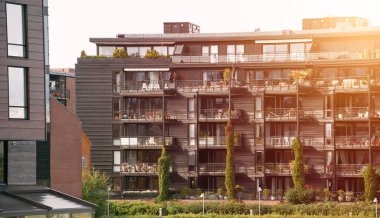 Balkonları ve yeşillikleri olan modern bir apartman.