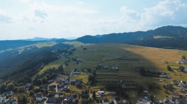 Canlı tarlaları ve dağ sıraları olan sakin bir kırsal bölge.