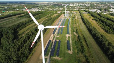 Kırsalda rüzgar türbini ve güneş panelleri