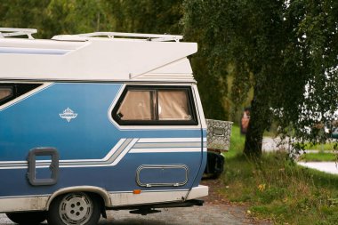 Ormanlık alana park etmiş mavi bir karavan. 20.09.2023 Norveç, Avrupa.
