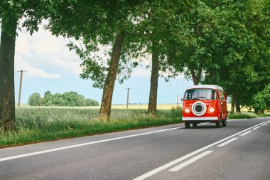 Red campervan on open road clipart