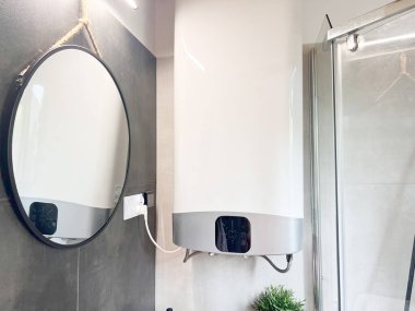 Ev banyosuna modern elektrikli su ısıtıcısı yerleştirildi.