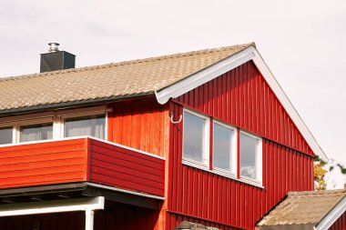 Su ve dağların yanındaki kırmızı ev.