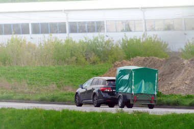 Araba kapalı bir karavanı dışarı çekiyor.